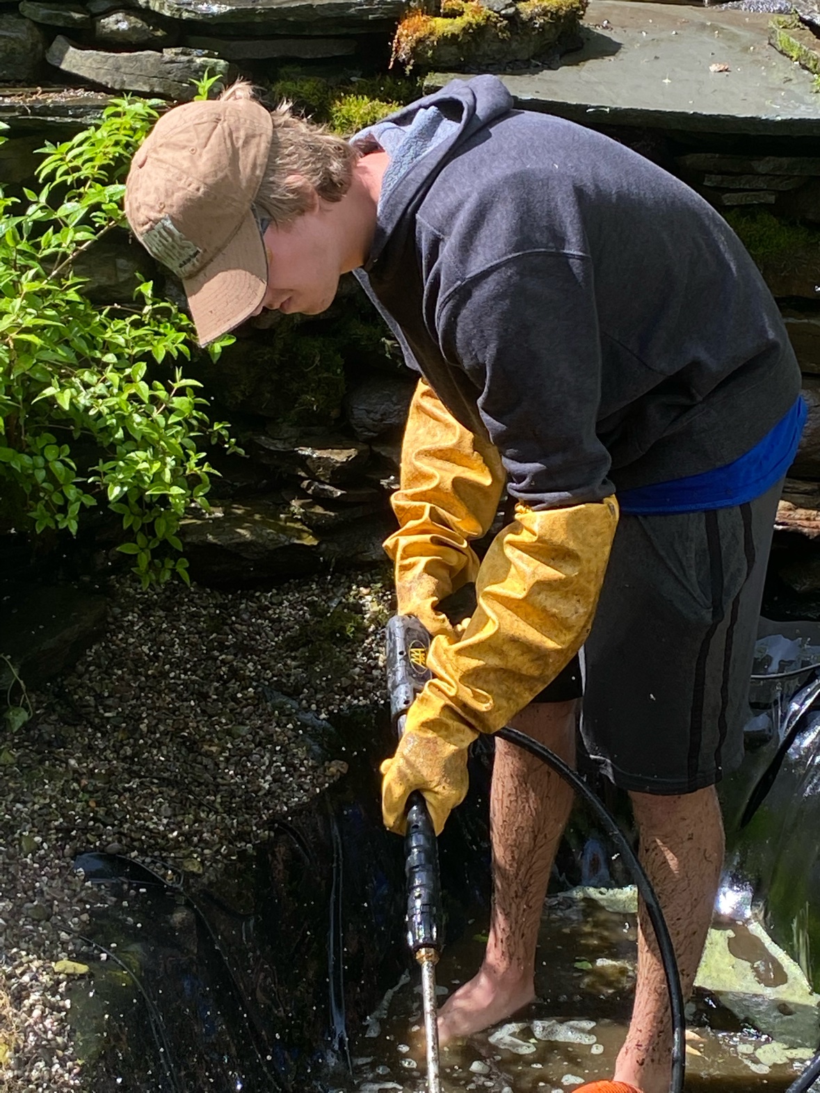 Pressure washing rock and gravel during a full pond cleanout